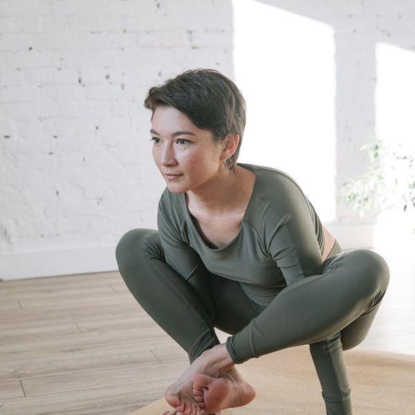 Woman meditating peacefully in a bright, sunlit room.